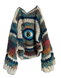 a crocheted sweater with an eye on it