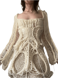 a woman wearing a white crocheted dress