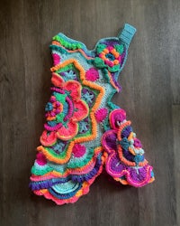 a colorful crocheted dress on a wooden floor